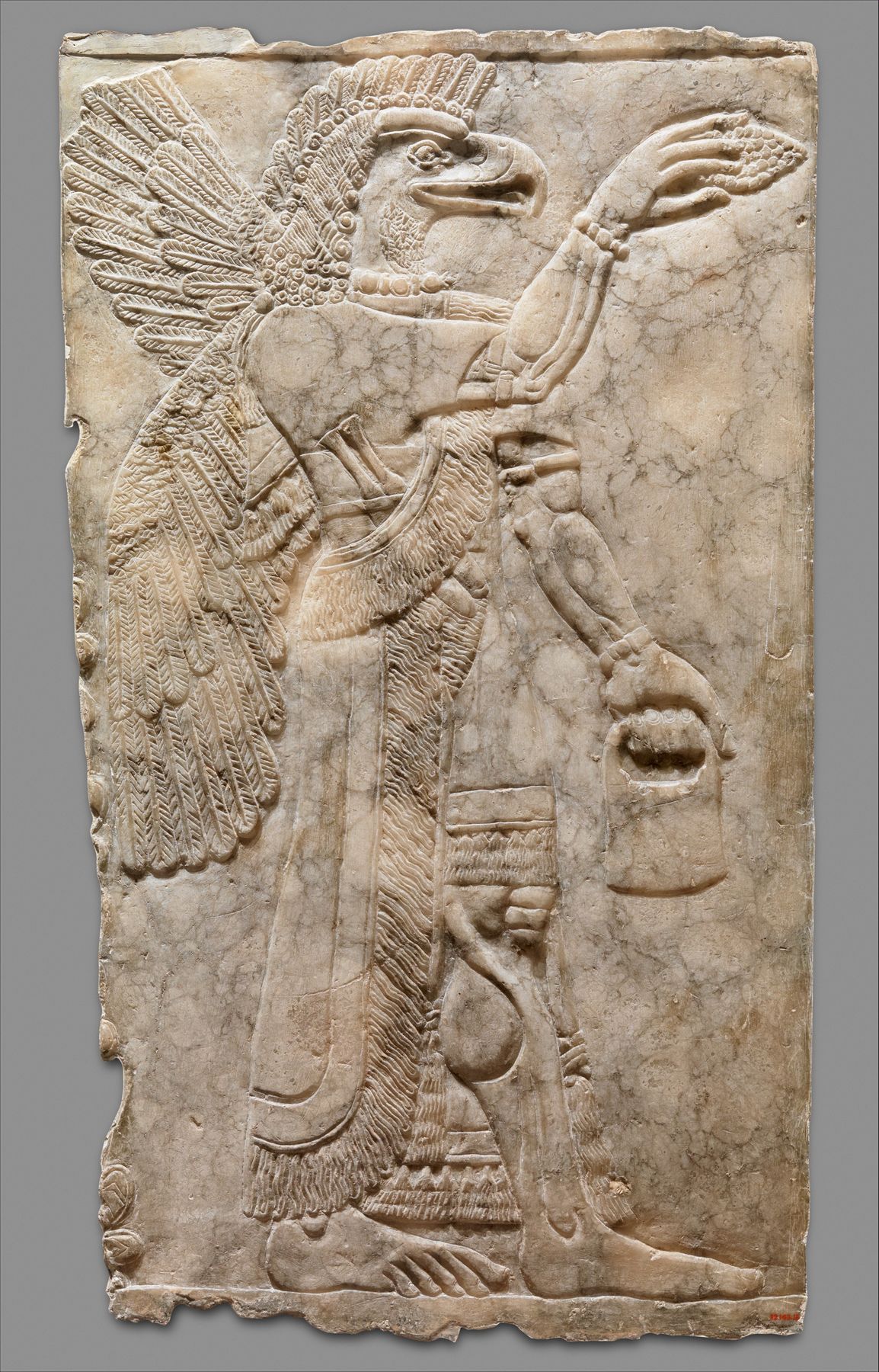 Neo-Assyrian relief panel: a winged, eagle-headed protective figure holding bucket and cone, Nimrud, ca. 883–859 BC